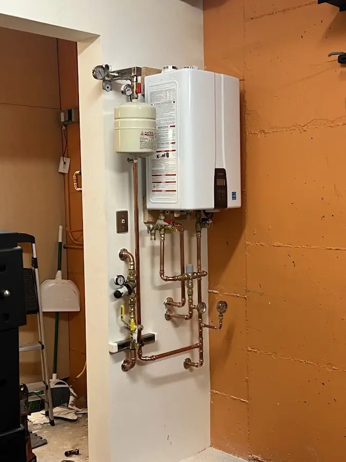 Plumbing technician inspecting water heater connections in Barboursville